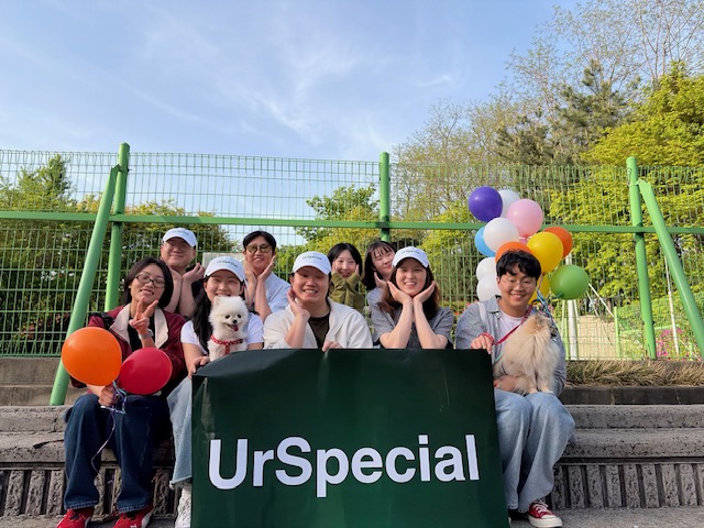 유어스페셜 야외 모임 — UrSpecial 배너 앞에 모인 사람들과 풍선